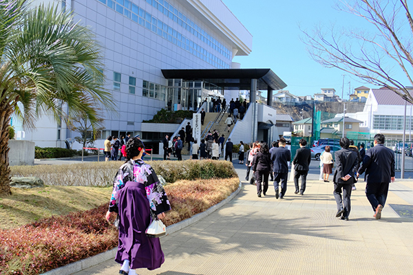 式場となった鶴記念体育館に向かう卒業生や修了生。袴姿の女子学生が目を引きます
