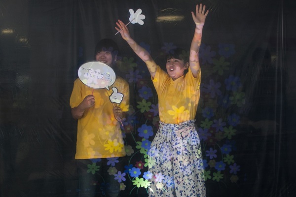 女子学生2人の前にある花柄マークは、透明スクリーンに投影された映像。ここにハートを映し出し「スキです！」なんてメッセージを流すこともできます。