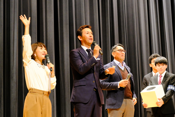 当選番号を読み上げる山内さん。住本さんも当選者探しをアシスト「当たった人は手を上げて～！」