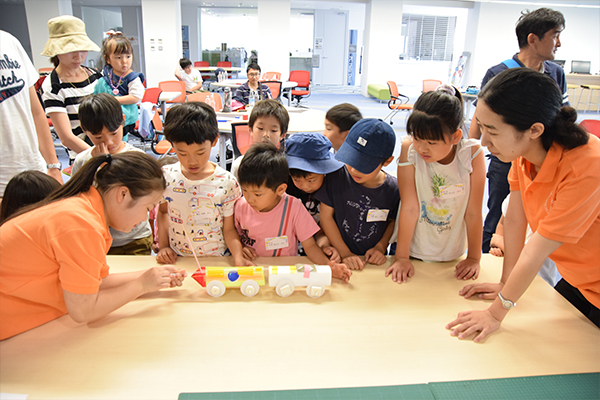 説明した原理をよりわかりやすく伝えるために、手作り模型を使った実験を子どもたちの前で実演。