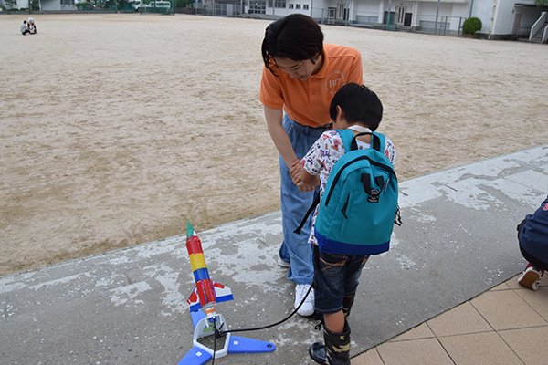 次にロケットを発射台にセットし空気を入れます。子ども一人では大変な作業なので、女子学生も一緒にお手伝い。