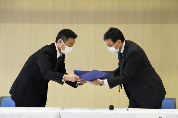JAF広島支部の岡本支部長と長坂学長、双方ともに署名をして協定書を交換した