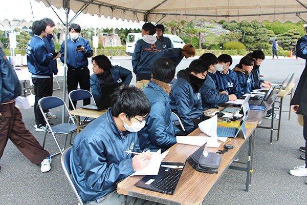 体育会本部テントでは、連携しながら次の走者の準備やタイムの記録などを行う