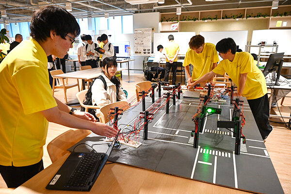 実際の交差点の信号機を、電気信号ごと再現した模型。プログラムで動かすクレーンゲームや触れると電気が流れる迷路などにも触れてもらった