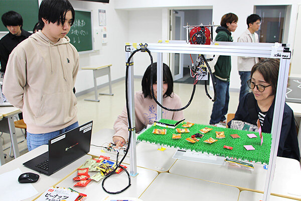 電気システム工学科の学生プロジェクト「HIT-ALPs」は、クレーンゲームを通して電気の楽しさを伝えた