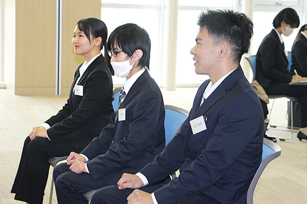 面接官の質問に笑顔で答える学生たち