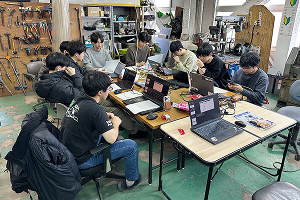 本学の学生フォーミュラチーム「HIT Formula Project」の部室で、学生たちが協働でPBLテーマに取り組む様子