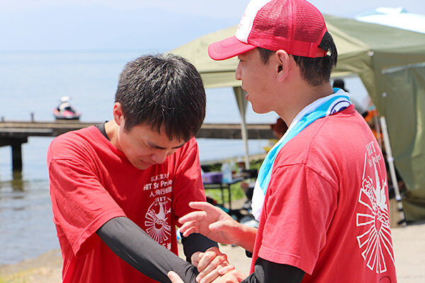 岸に戻った合田さんを囲み、仲間たちが温かく励ました