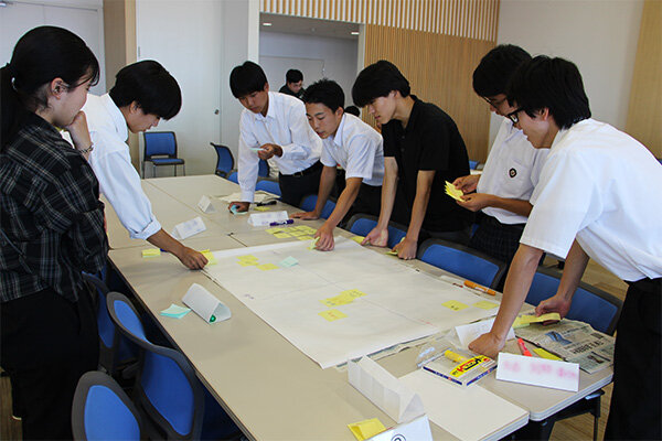 本学学生のサポートを受けながら、職業を分類する高校生たち